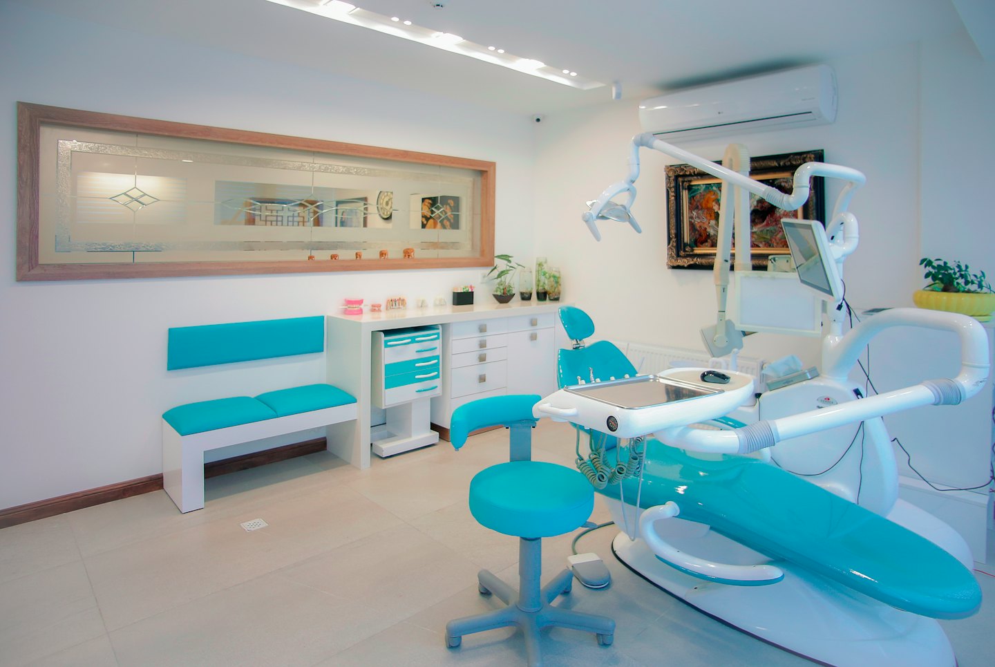 Moderna clinica dentistica con poltrona turchese e panca d'attesa.
